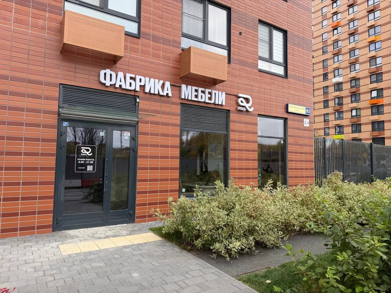 Вход в шоурум мебельной фабрики Рось в кирпичном здании на улице Александры Монаховой, 83